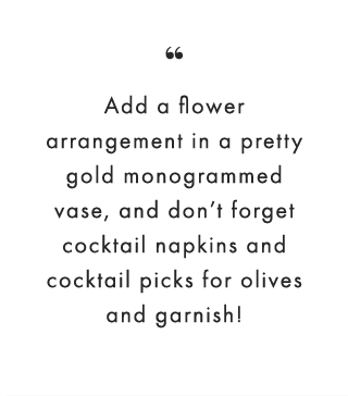 “Add a flower arrangement in a pretty gold monogrammed vase, and don’t forget cocktail napkins and cocktail picks for olives and garnish!