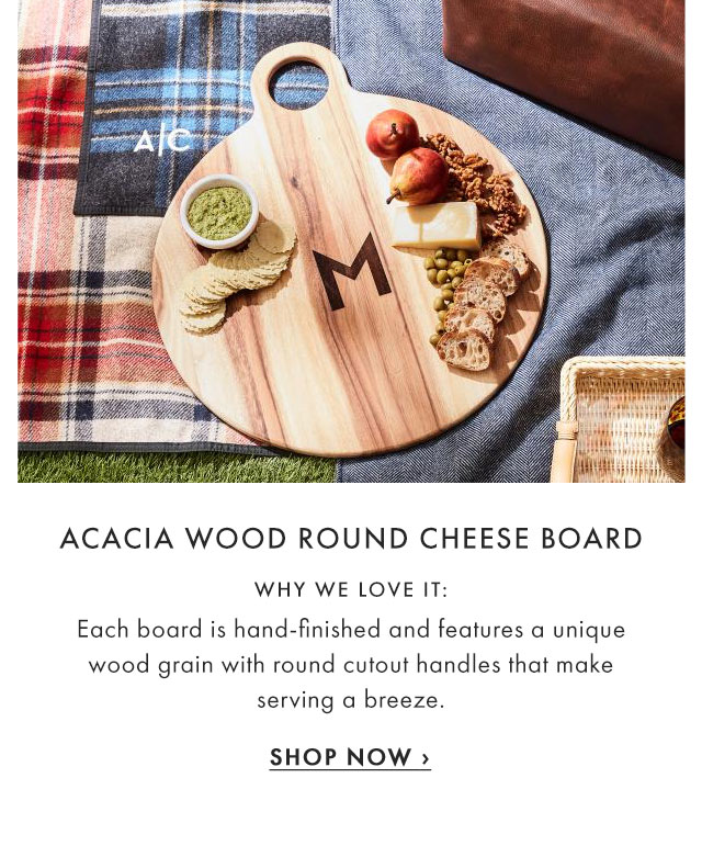 ACACIA WOOD ROUND CHEESE BOARD - WHY WE LOVE IT: Each board is hand-finished and features a unique wood grain with round cutout handles that make serving a breeze. - SHOP NOW ›